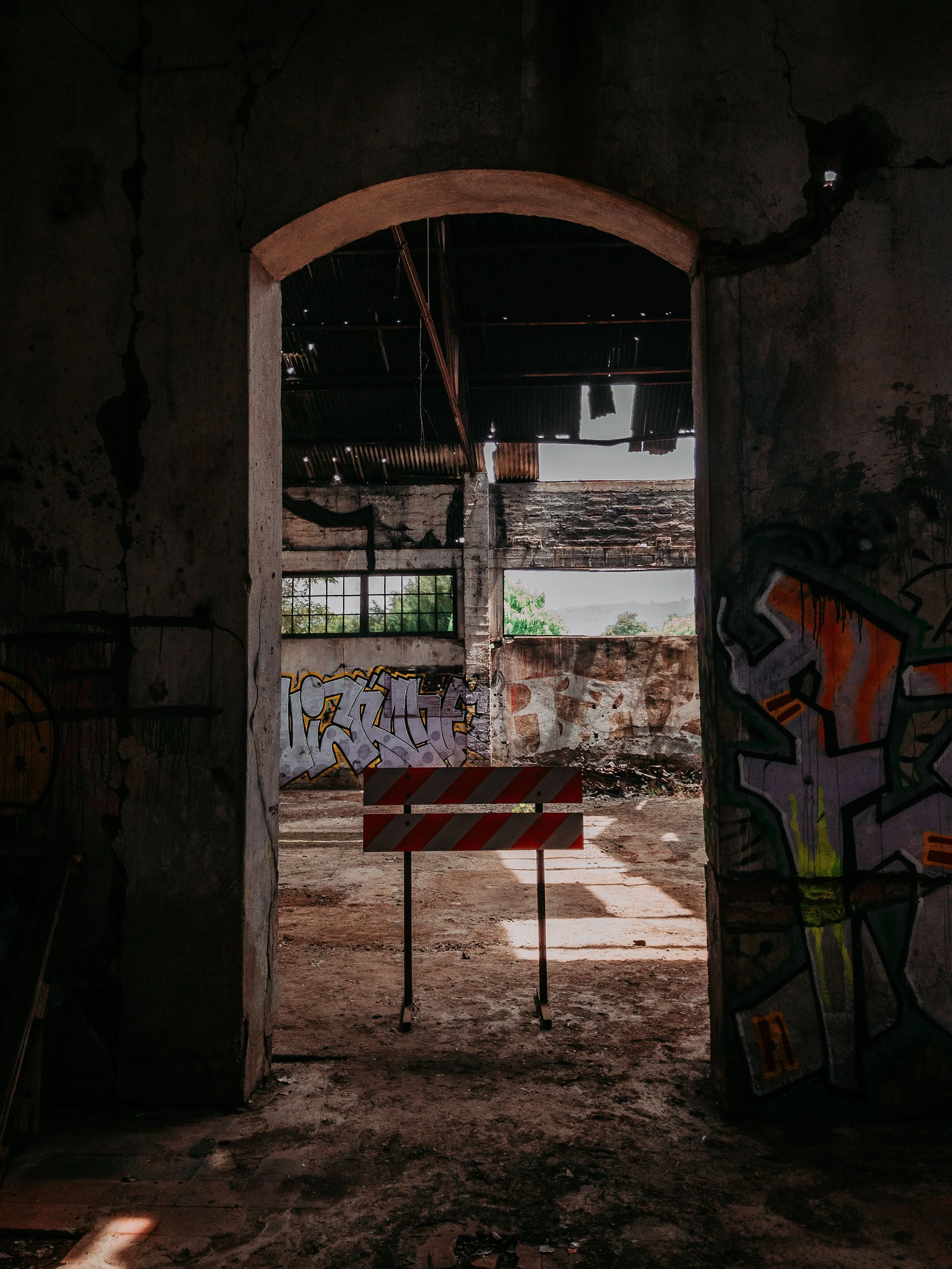 A dark, graffiti-covered doorway opening into an abandoned space.