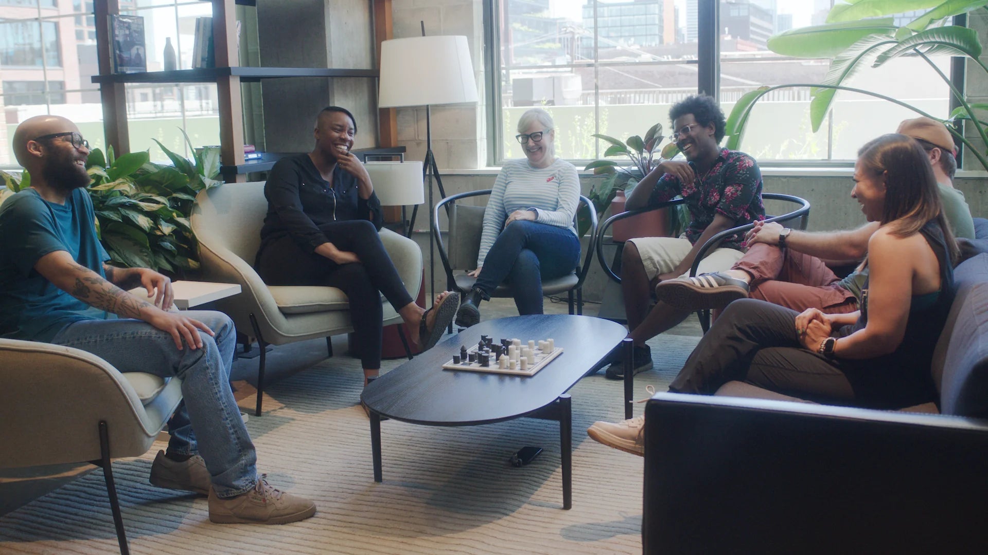 Group of people sitting in chairs laughing